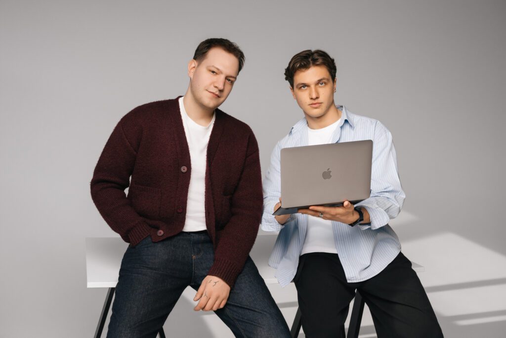 Two founders sitting with a laptop during a studio photoshoot, representing the Backoffice startup team.